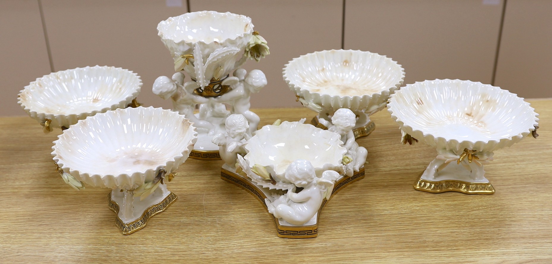 Six pieces of Moore Bros. white glazed gilt edged porcelain, including a set of four comport, 20cm tall